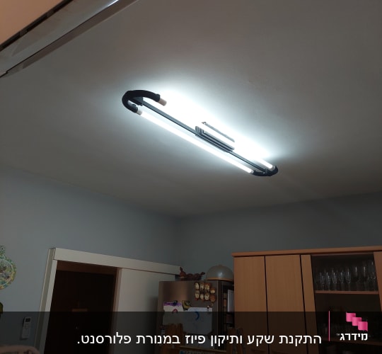 תאורת פלורסנט מותקנת על תקרה עם סולם עץ מתחתיה